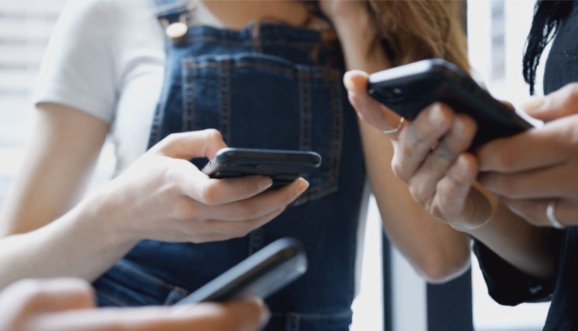 close-up-of-businesswomen-using-mobile-phones-in-modern-office