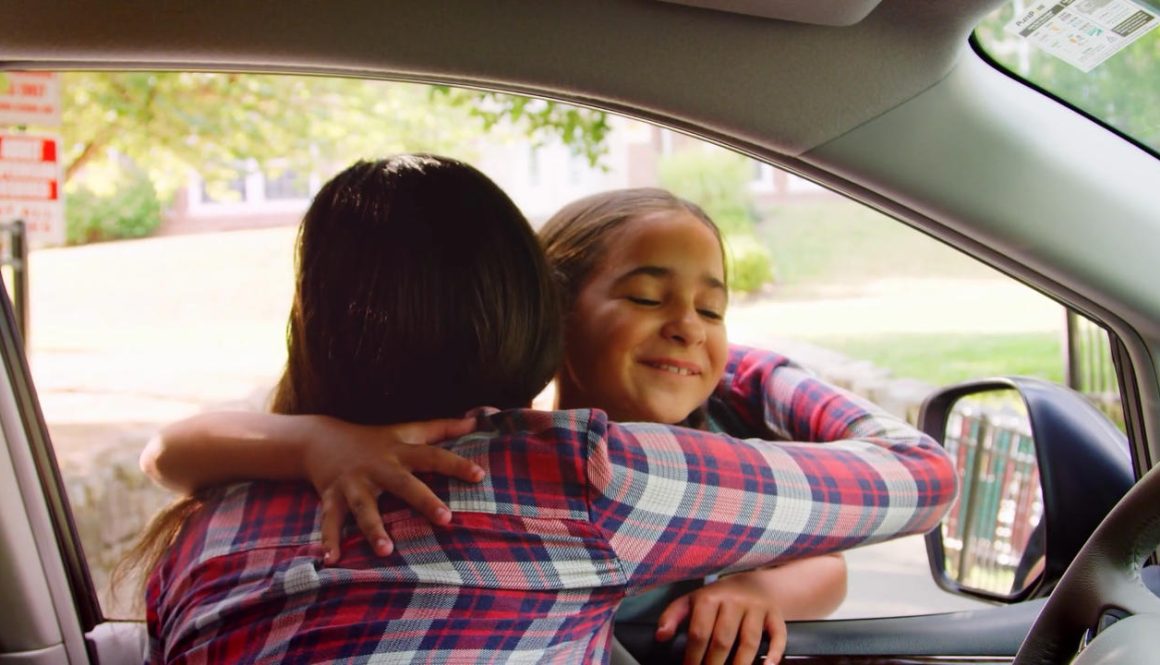 mother-in-car-dropping-off-daughter-in-front-of-school